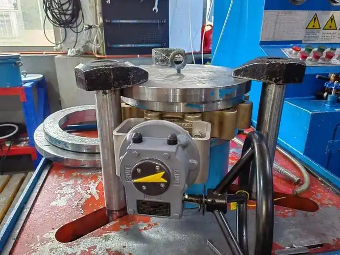 A butterfly valve clamped closed on a hydrostatic test bench with water on the downstream face of the disc, watched by a technician in safety glasses.