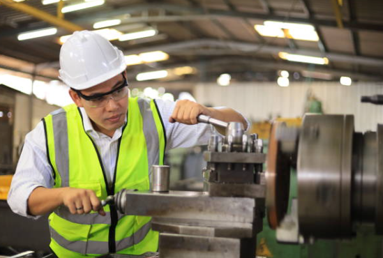 Mechanic Worker is Working With Lathe Machine Inside the Factory